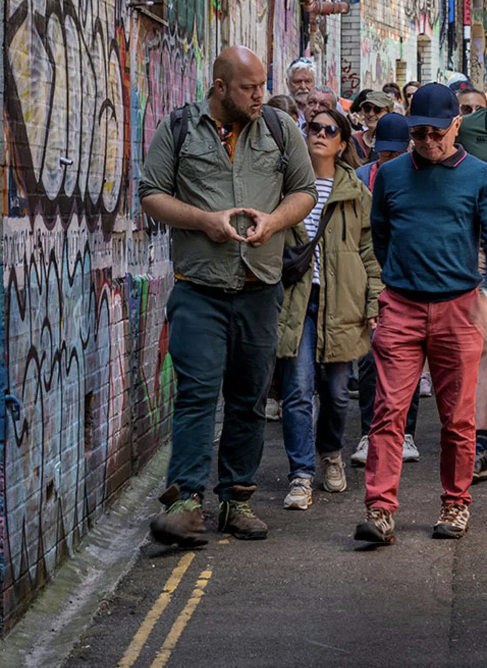 Luke Sargeant leading guests through a Bristol street art alleyway on a walking tour